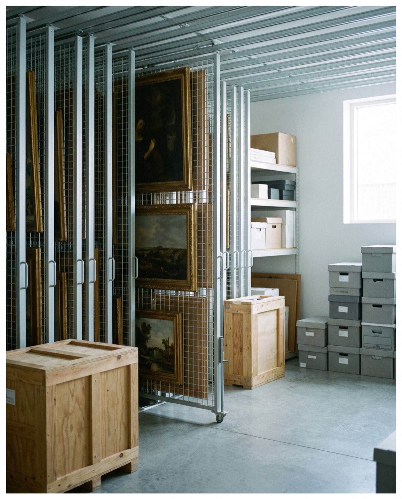 Réserve de la galerie, œuvres rangées sur des racks métalliques.